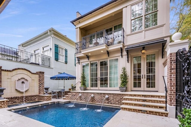 rear view of house featuring a patio, french doors, and a balcony