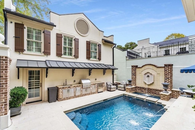 rear view of house featuring pool water feature, area for grilling, and a patio area