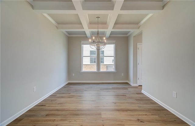 unfurnished dining area featuring beamed ceiling, coffered ceiling, light hardwood / wood-style flooring, and an inviting chandelier