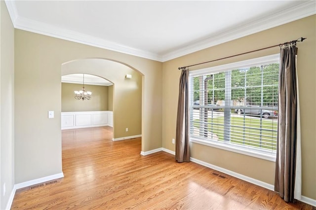 2359 Saint Kennedy Ln, Buford, GA 30518 - empty room with ornamental molding, arched walkways, a chandelier, and light wood-style floors