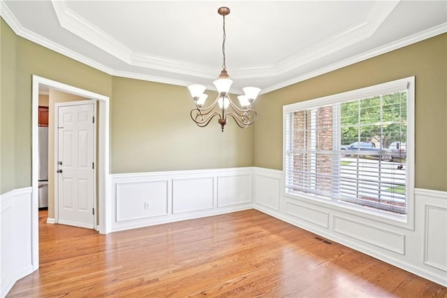 2359 Saint Kennedy Ln, Buford, GA 30518 - unfurnished room with light wood-style flooring, a tray ceiling, crown molding, a chandelier, and a wainscoted wall