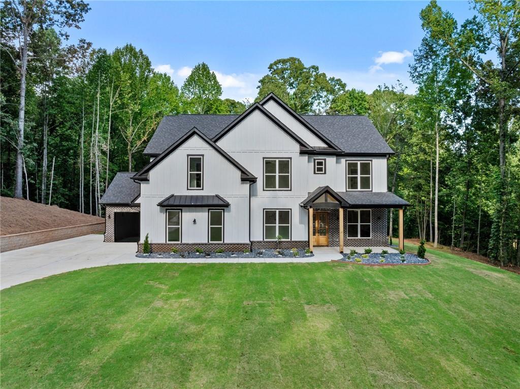 modern farmhouse style home with a garage and a front lawn