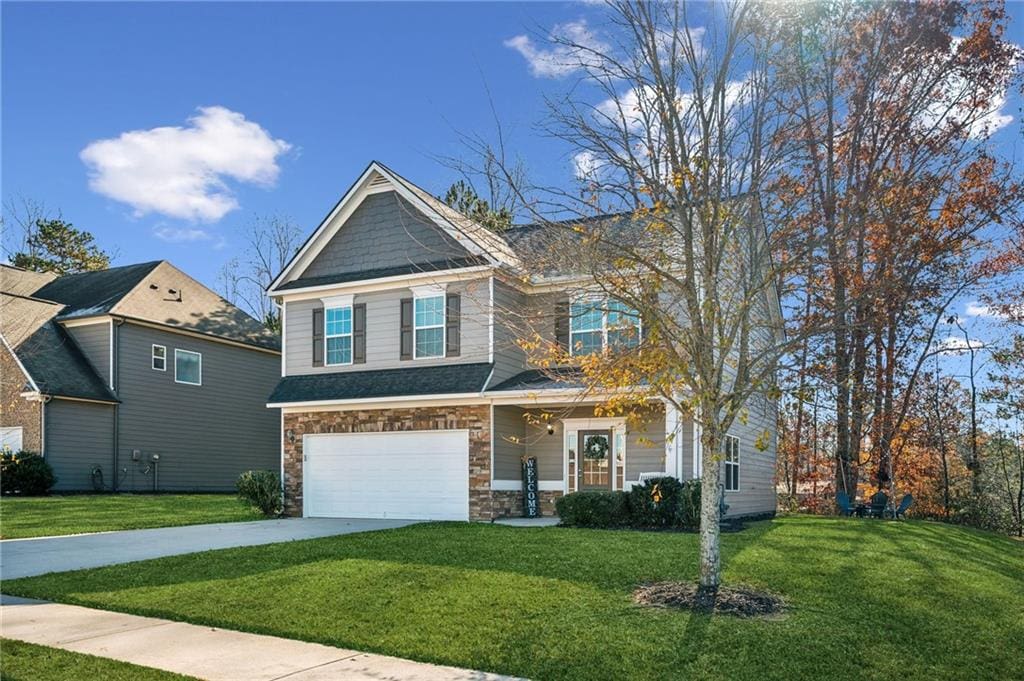 view of front of property featuring a garage and a front lawn