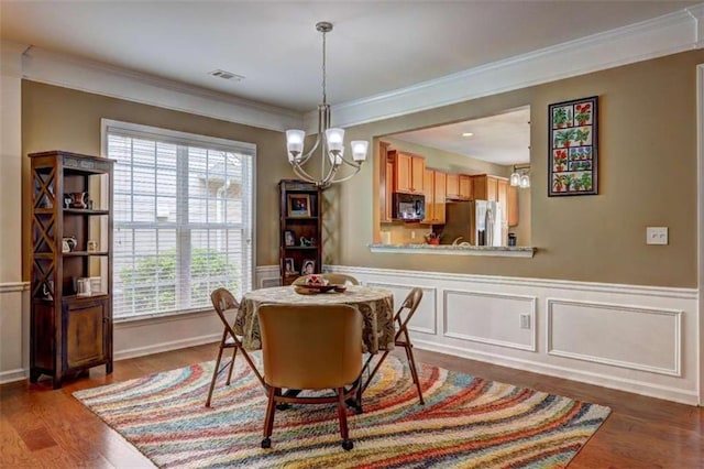 802 Dusky Sap Ct, Griffin, GA 30223 - dining area with a chandelier, ornamental molding, dark wood-style flooring, and wainscoting
