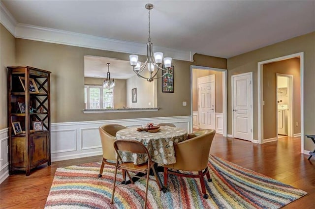 802 Dusky Sap Ct, Griffin, GA 30223 - dining space featuring a chandelier, wood finished floors, wainscoting, ornamental molding, and a decorative wall