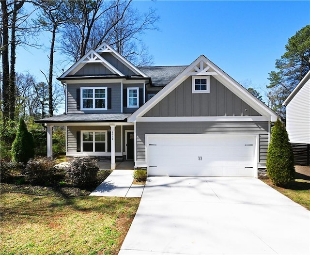 craftsman-style home with a porch, board and batten siding, concrete driveway, a front yard, and an attached garage