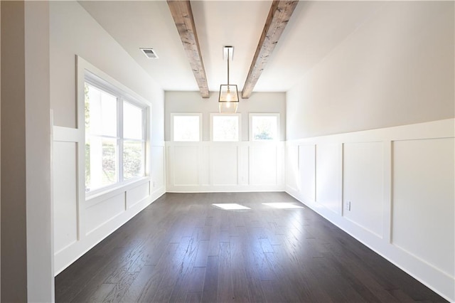 unfurnished dining area featuring visible vents, beam ceiling, dark wood-style floors, and a decorative wall