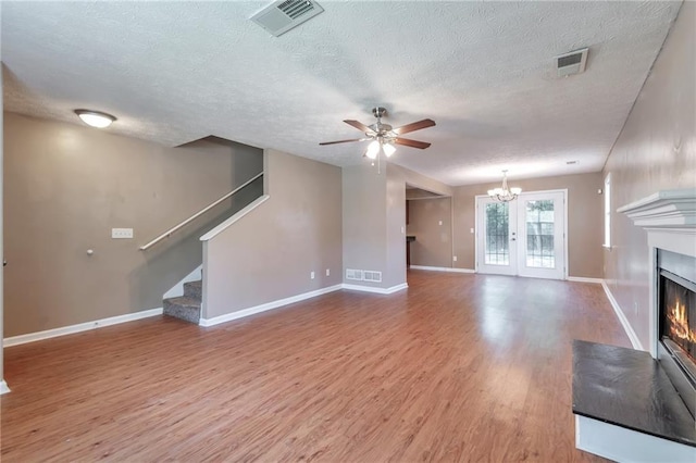 912 Third St, Stone Mountain, GA 30083 - unfurnished living room with a glass covered fireplace, wood finished floors, ceiling fan, stairs, and a textured ceiling