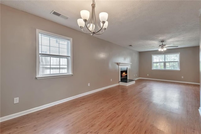 912 Third St, Stone Mountain, GA 30083 - unfurnished living room with a textured ceiling, wood finished floors, a warm lit fireplace, baseboards, and a ceiling fan