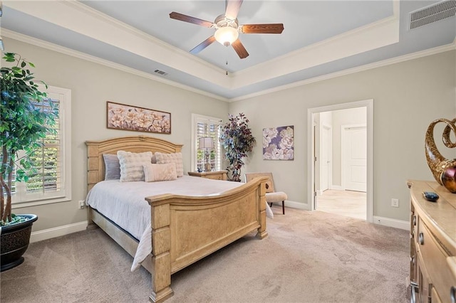 bedroom featuring visible vents, light colored carpet, and a raised ceiling