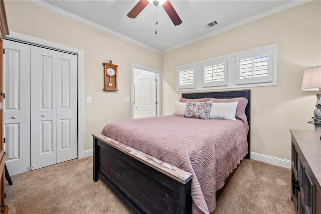 bedroom featuring baseboards, visible vents, ornamental molding, a closet, and light colored carpet