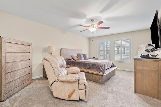 bedroom with a ceiling fan, baseboards, and light carpet