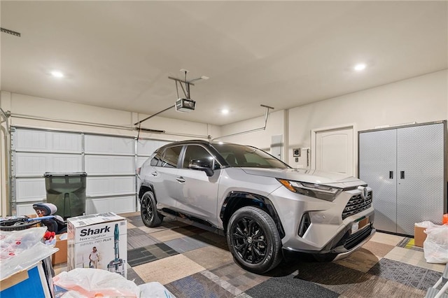 garage with recessed lighting and a garage door opener