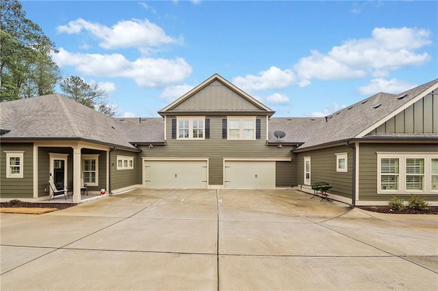 exterior space with an attached garage, concrete driveway, board and batten siding, and a shingled roof