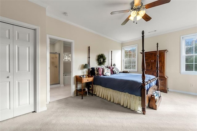 bedroom with a closet, crown molding, light colored carpet, ceiling fan, and ensuite bathroom