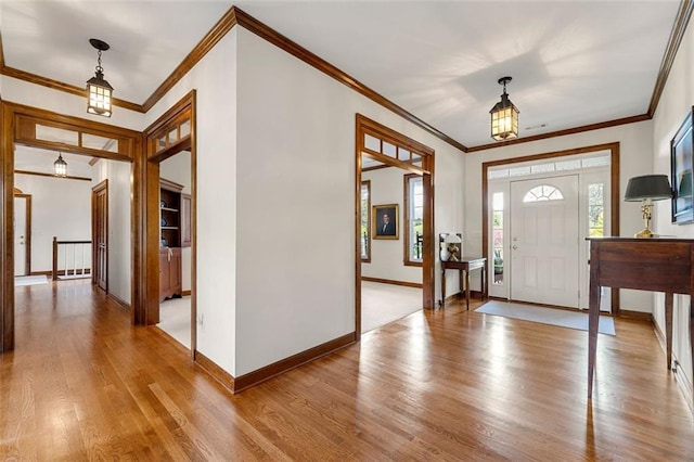 foyer featuring ornamental molding and light hardwood / wood-style flooring