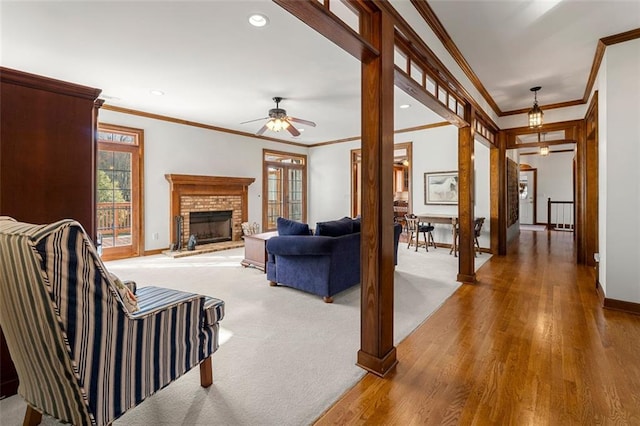 living room featuring ornate columns, hardwood / wood-style floors, ceiling fan, and crown molding