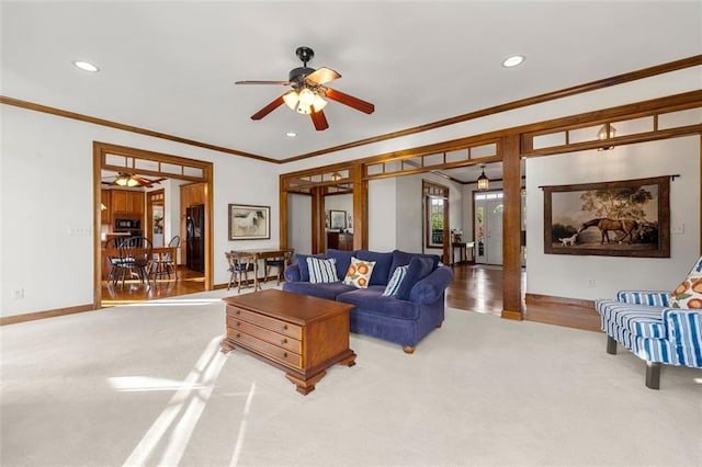 living room featuring ceiling fan, wood-type flooring, and ornamental molding