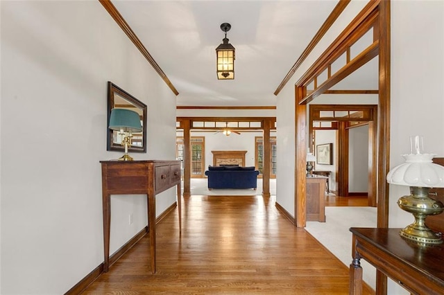 hall with wood-type flooring and ornamental molding