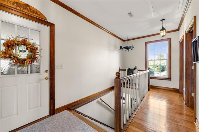 entrance foyer featuring ornamental molding and light hardwood / wood-style floors