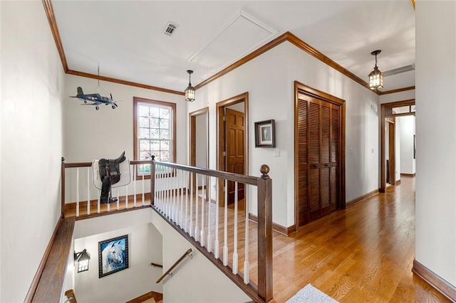 hallway with light wood-type flooring and ornamental molding