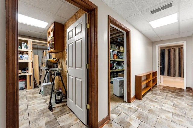 hallway with a paneled ceiling