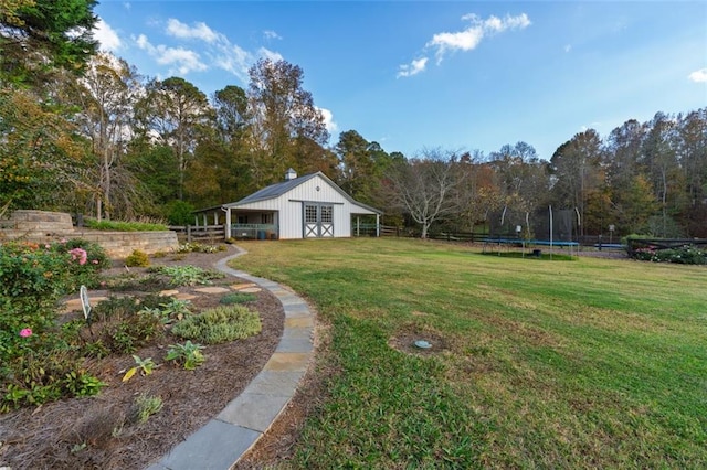 view of yard featuring an outdoor structure and a trampoline