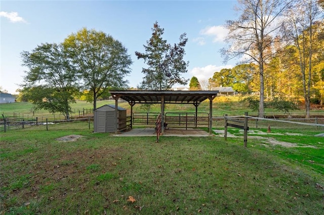 view of home's community with a shed, a rural view, and a yard