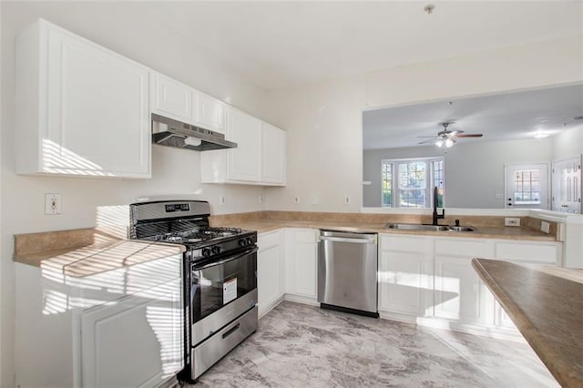 kitchen with light tile floors, ceiling fan, appliances with stainless steel finishes, white cabinetry, and sink