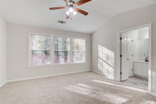 carpeted spare room with ceiling fan, a healthy amount of sunlight, and vaulted ceiling