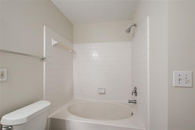 bathroom with toilet and tiled shower / bath