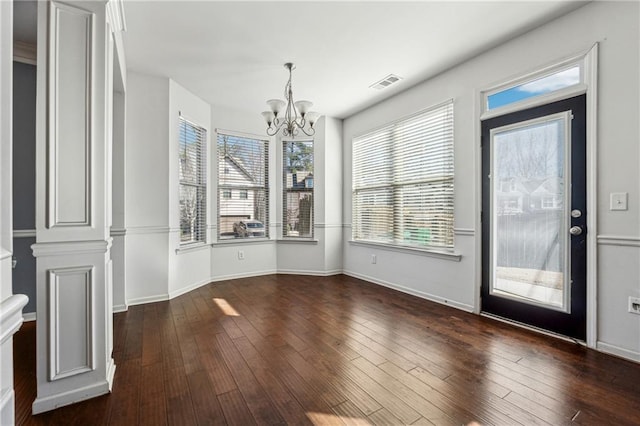 unfurnished dining area featuring dark hardwood / wood-style floors and a notable chandelier