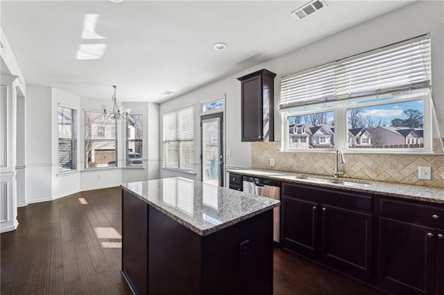 kitchen featuring dark hardwood / wood-style floors, backsplash, a chandelier, a kitchen island, and sink