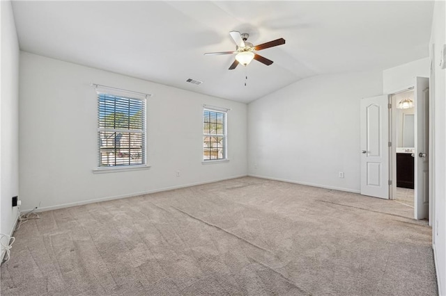 carpeted spare room featuring ceiling fan and vaulted ceiling