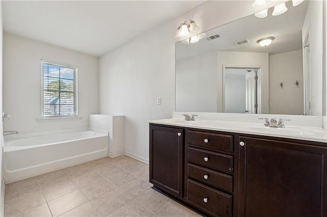 bathroom featuring tile patterned floors, a bathtub, and vanity