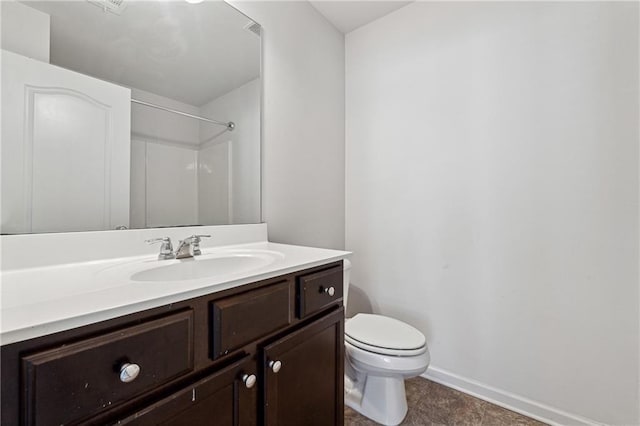 bathroom featuring toilet, vanity, and walk in shower