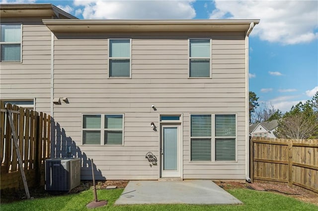 rear view of house featuring a lawn, central air condition unit, and a patio area