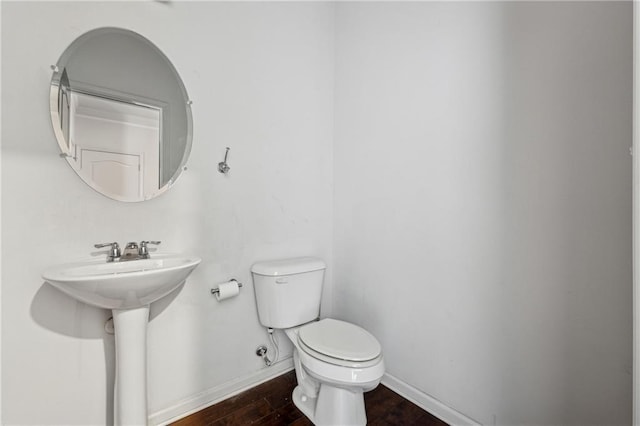 bathroom with toilet, sink, and hardwood / wood-style flooring