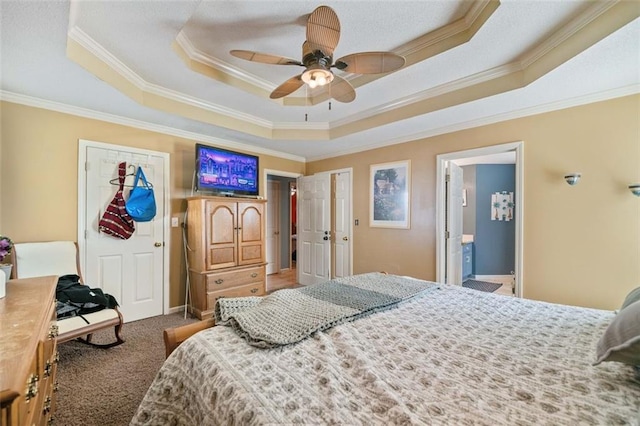 carpeted bedroom featuring ornamental molding, a raised ceiling, ceiling fan, and ensuite bathroom