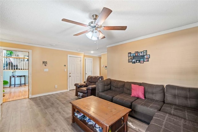 living room featuring hardwood / wood-style flooring, ceiling fan, ornamental molding, and a textured ceiling