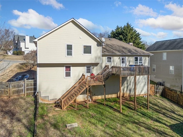 back of house with a wooden deck and a lawn