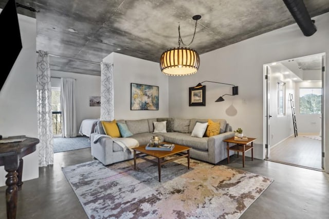 living room with a wealth of natural light, concrete floors, and a barn door