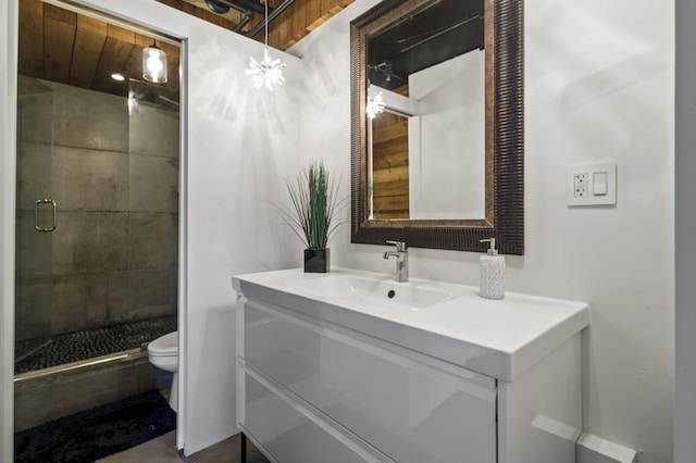 bathroom featuring vanity, an enclosed shower, and toilet