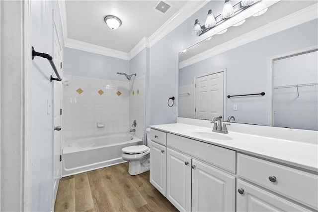 full bathroom with tiled shower / bath, vanity, toilet, crown molding, and hardwood / wood-style floors