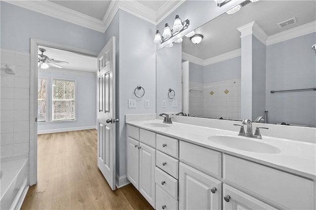 bathroom with ceiling fan, vanity, ornamental molding, and hardwood / wood-style flooring