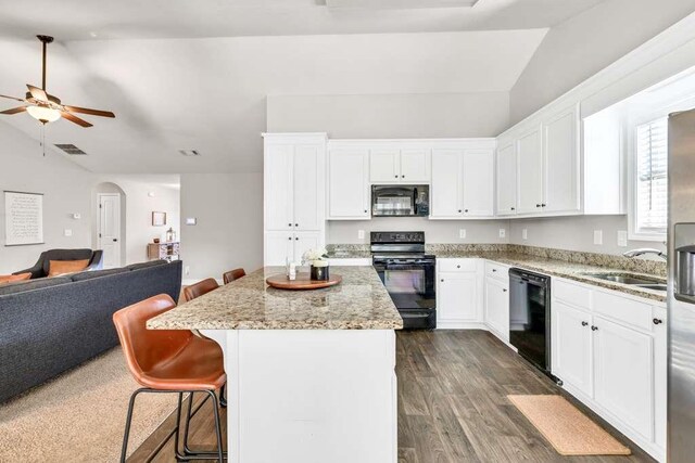 kitchen featuring black appliances, lofted ceiling, open floor plan, ceiling fan, and a center island