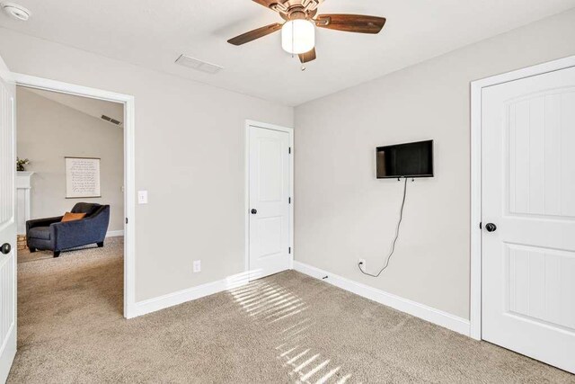 unfurnished bedroom featuring carpet, baseboards, and ceiling fan