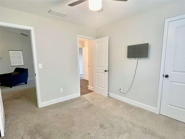 unfurnished bedroom featuring carpet floors, baseboards, and a ceiling fan