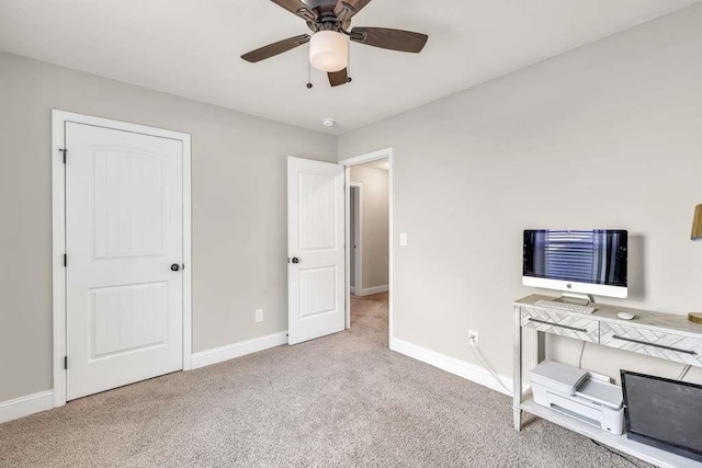 unfurnished bedroom featuring carpet, baseboards, ceiling fan, and a desk