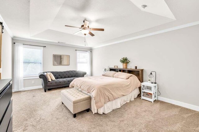 bedroom featuring a tray ceiling, light carpet, baseboards, crown molding, and a ceiling fan